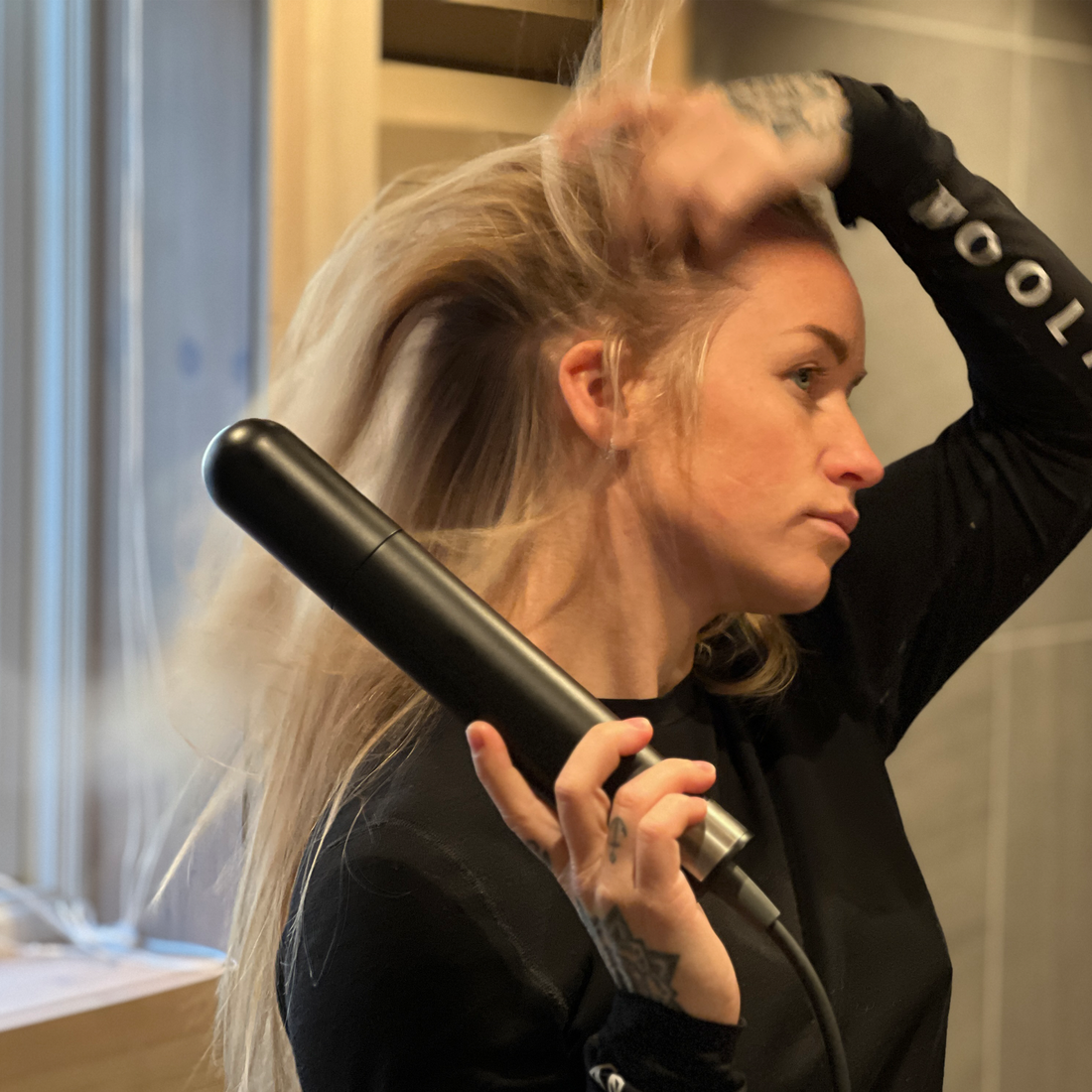 Woman uses Hedgehog GO travel dryer to dry her hair